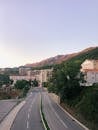 White and Brown Concrete Building Near Green Trees and Mountain
