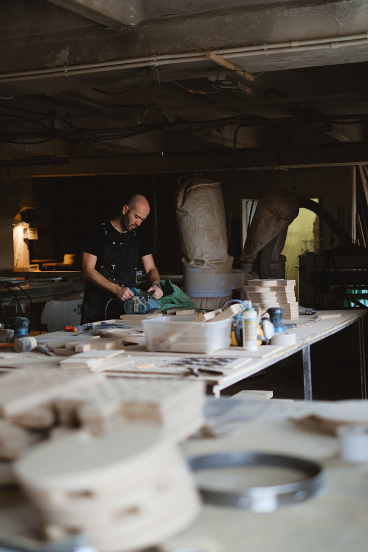 Woodworker Polishing Wood In Workshop