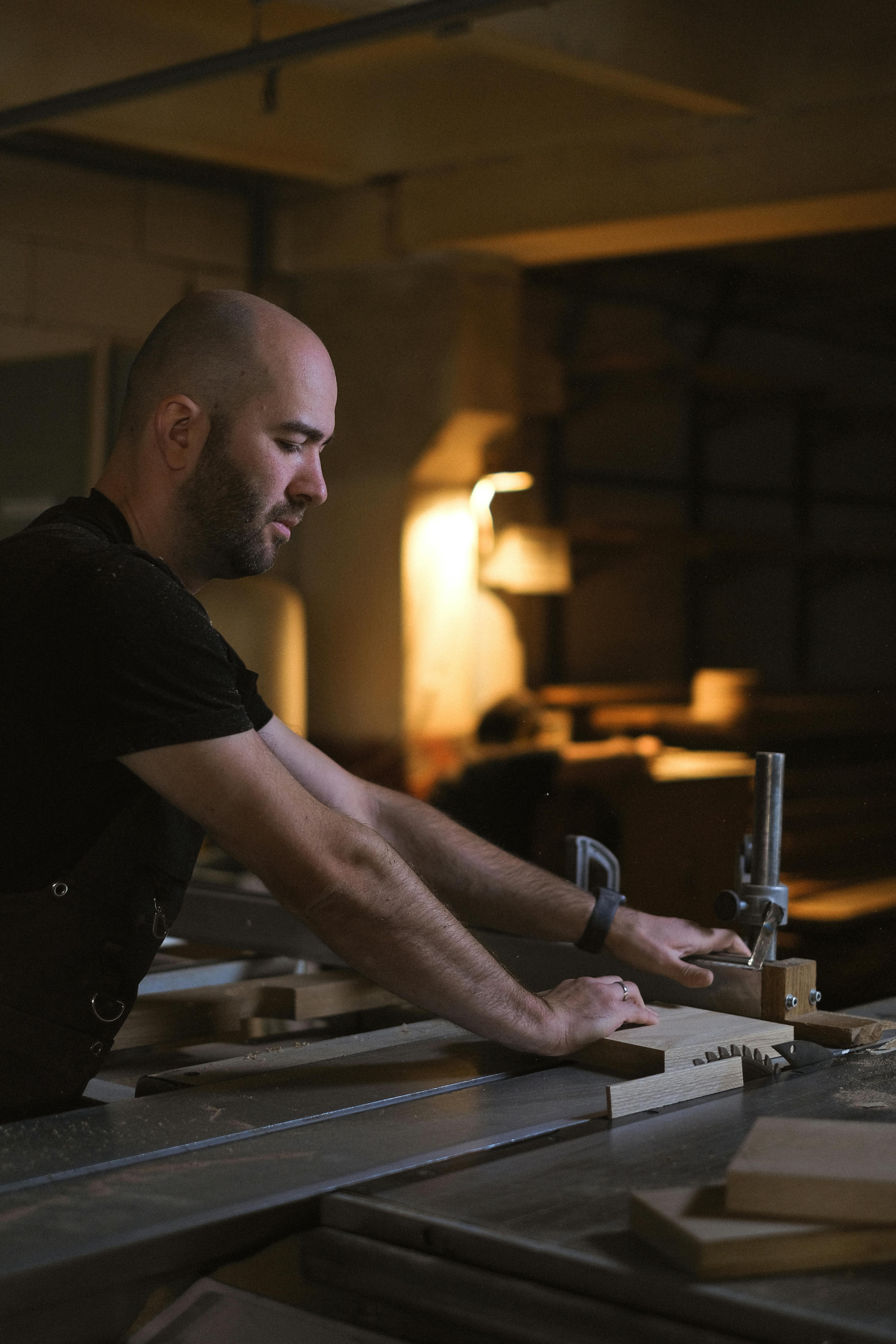 skilled artisan cutting wood at table saw