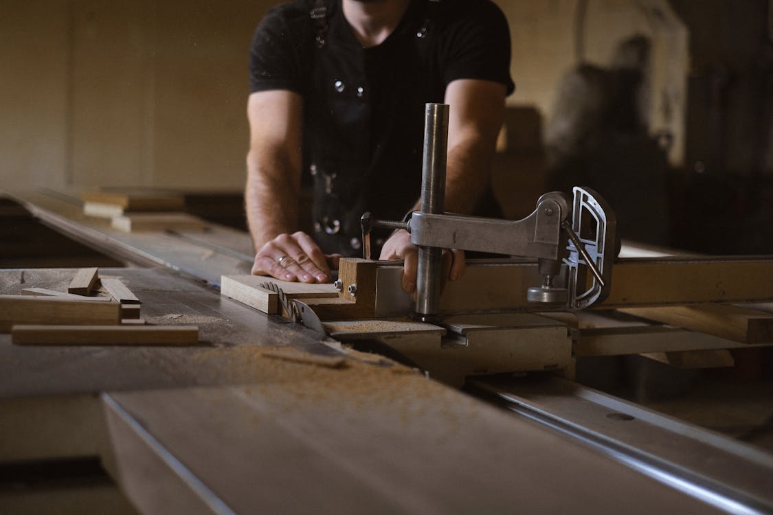 Carpenter cutting wood in his workshop