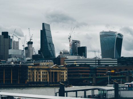 Cityscape of London's skyline with modern skyscrapers and a cloudy sky.