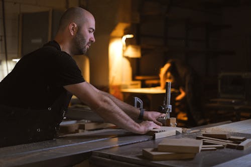 Craftsman cutting wood in workshop