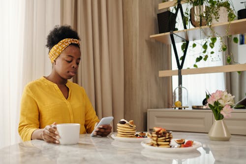 Free Woman with a Yellow Headband Using Her Phone Stock Photo