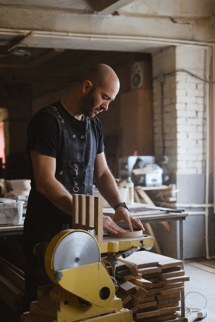 Focused Craftsman Grinding Wood In Joinery