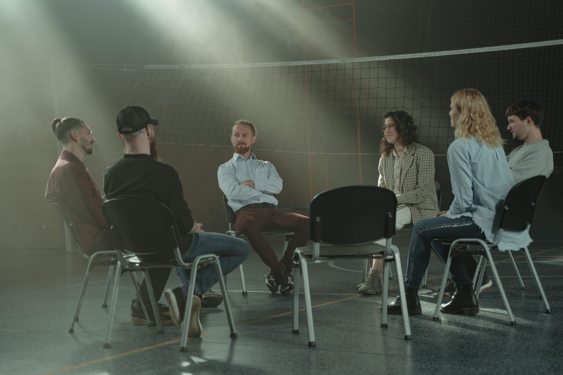 數位生活焦慮自救指南:科技與心靈平衡術 A group therapy session with six adults seated in a circle, discussing support and mental health.