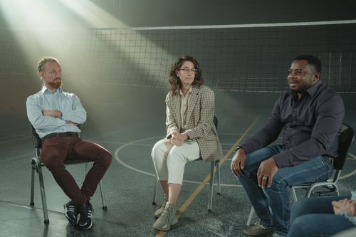 Free A multicultural group of people participating in a supportive therapy session indoors, fostering diversity and discussion. Stock Photo