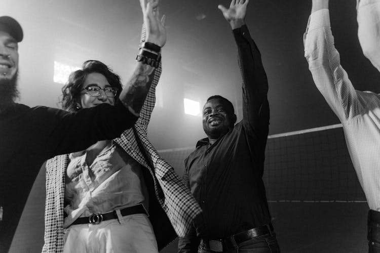 A Group Of People Wearing Long Sleeves Raising Their Hand