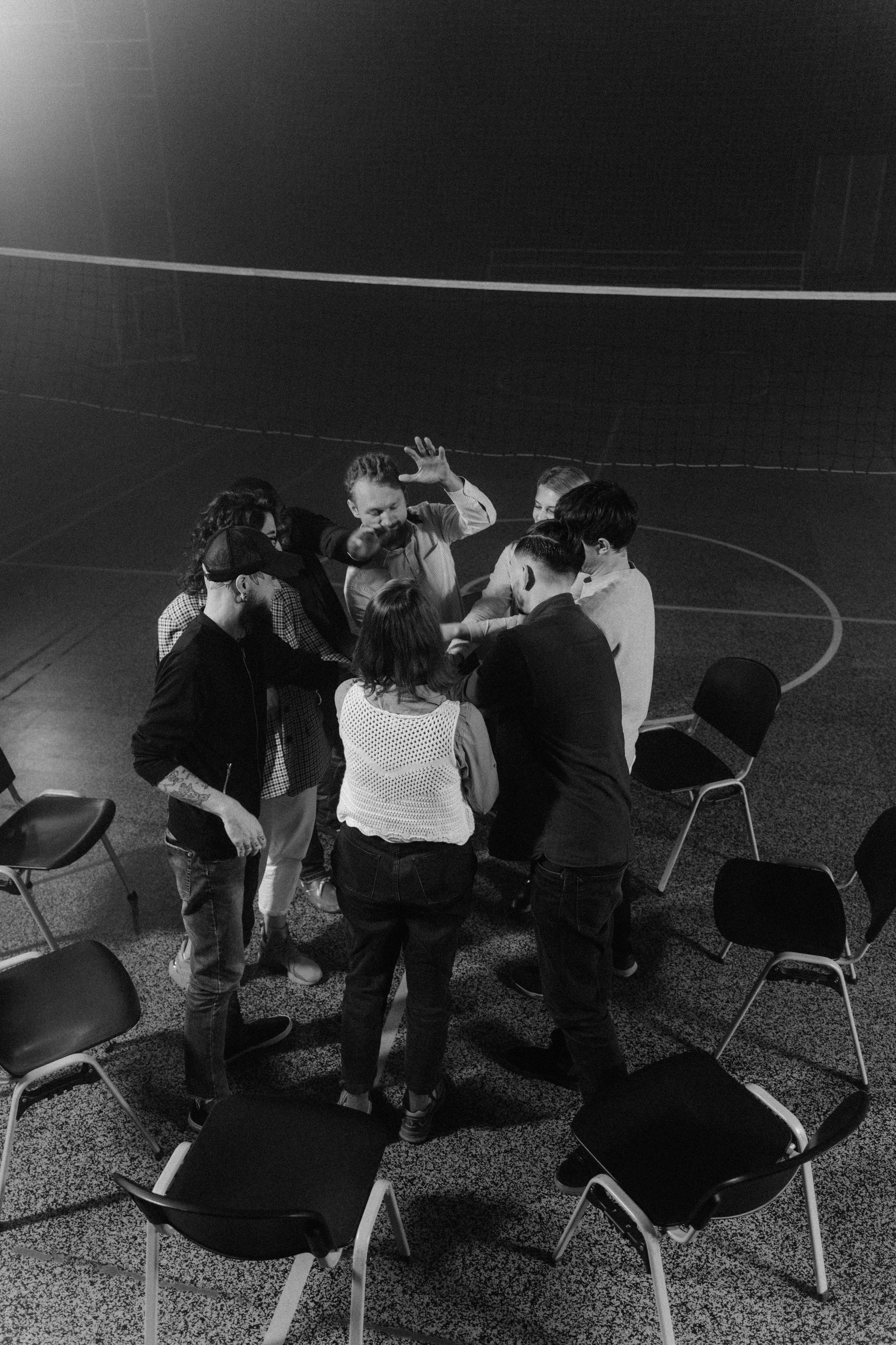 grayscale photo of people standing on gray concrete floor