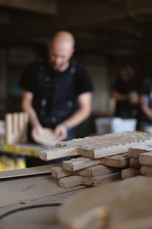 Unrecognizable craftsman working with wood at workbench