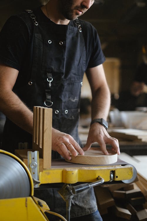 Free Crop artisan working with belt and disc sander Stock Photo