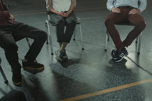 People Sitting on Chairs in Close-up Photography