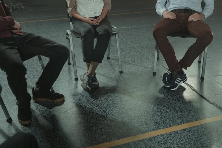 People Sitting On Chairs In Close-up Photography