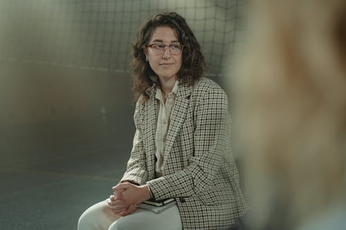 A Woman Sitting Wearing Plaid Long Sleeves