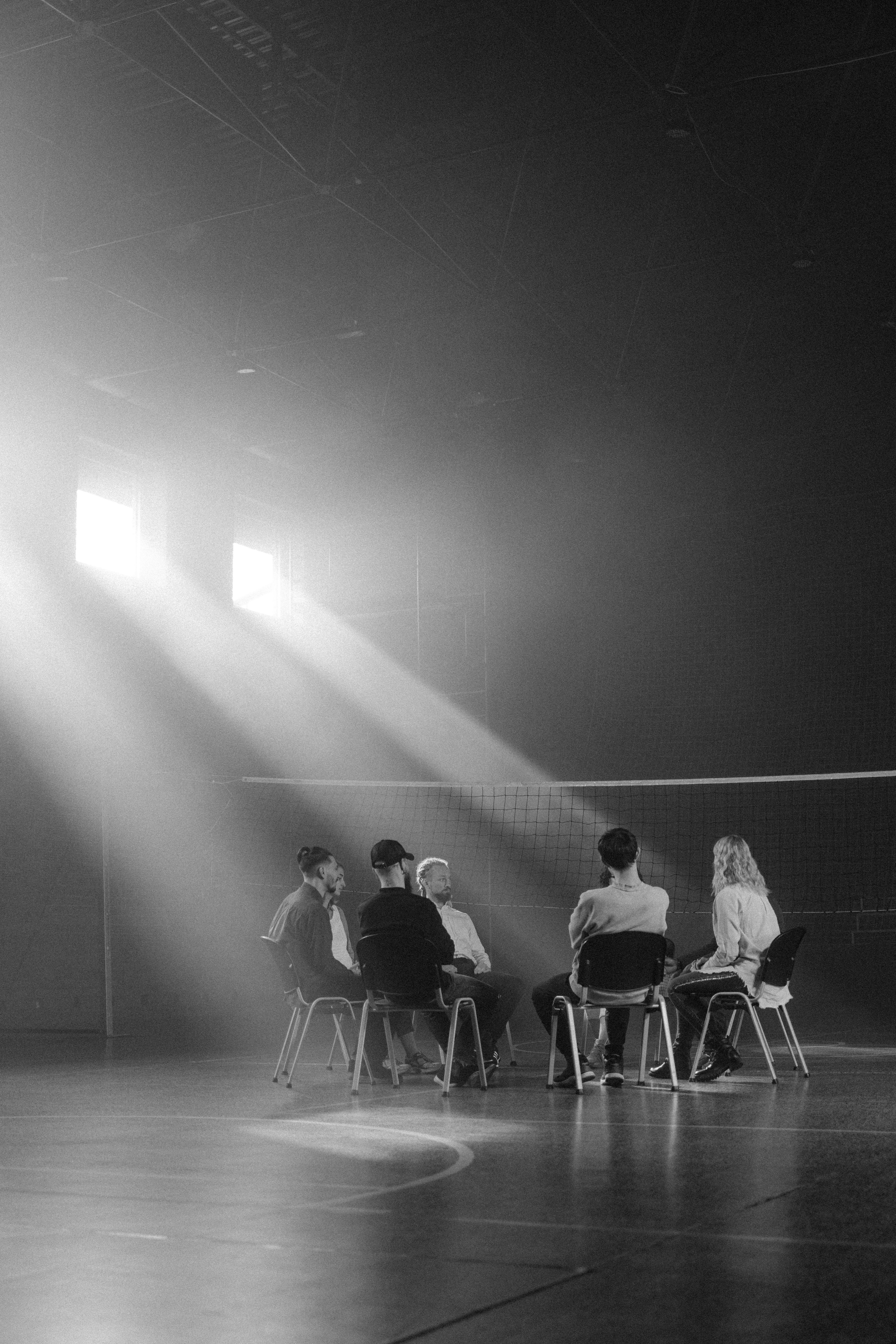 grayscale photo of people sitting on chair