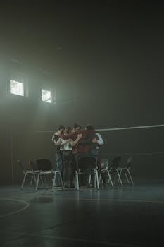 A diverse support group hugs in a dimly lit room, fostering unity and emotional support.