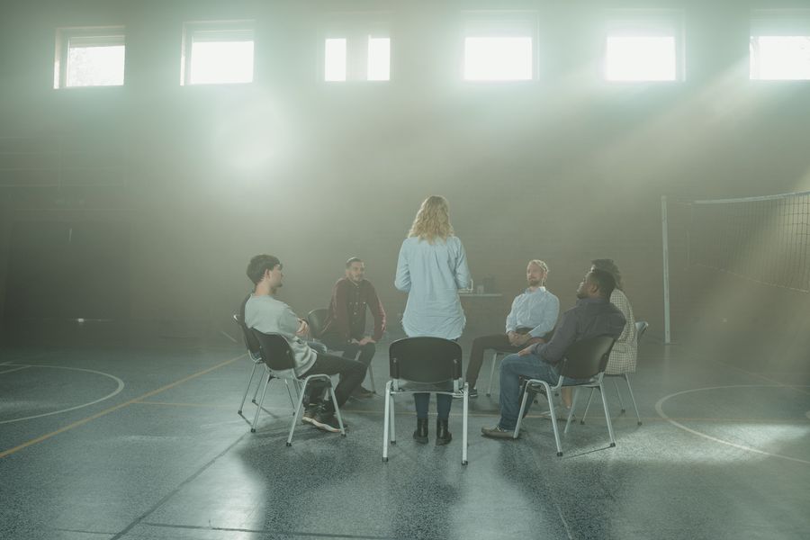 A group seated in a circle during a session in a sunlit hall. Photo by Tima Miroshnichenko on Pexels