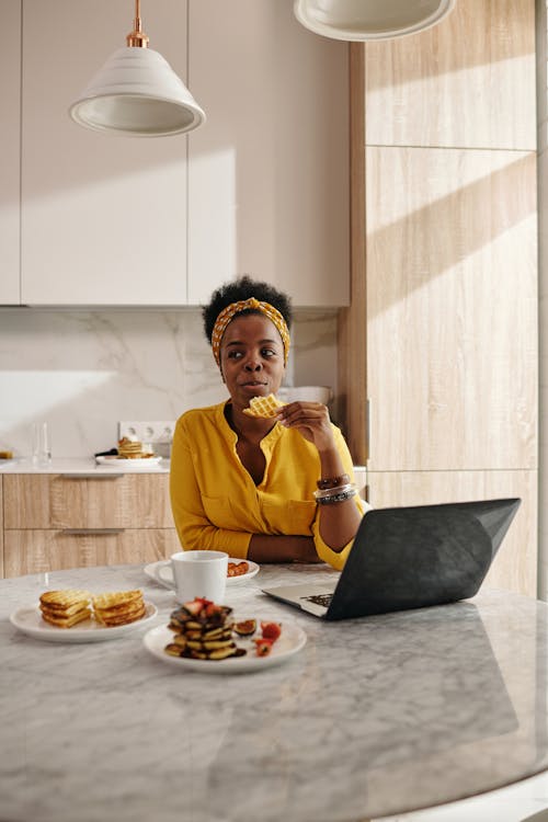 Free Woman Eating While In Front of a Laptop Stock Photo