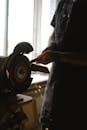 Crop master in apron sharpening wooden plank