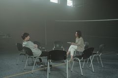 A one-on-one therapy session taking place indoors in a gymnasium setting.