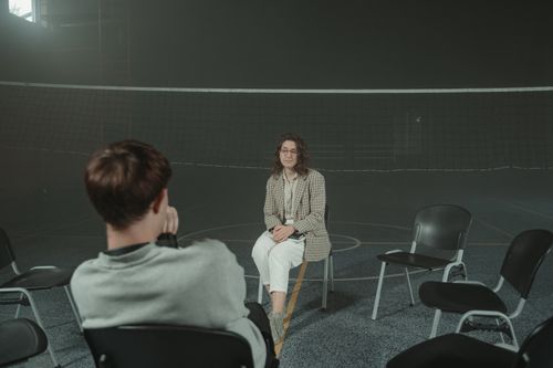 Free Two people engaged in a psychological support session in a gym setting, focused on mental health and therapy. Stock Photo