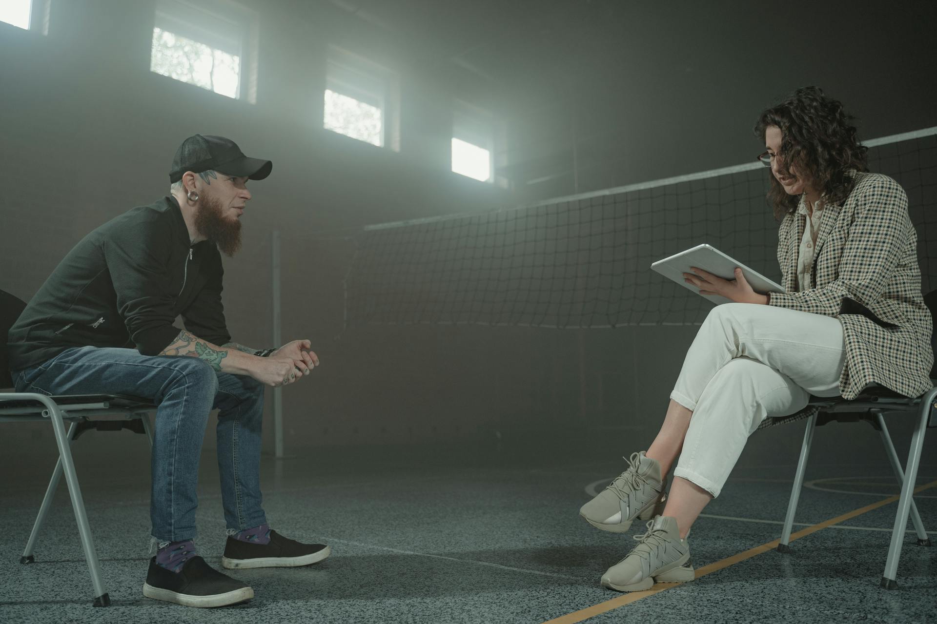 A man and woman engaged in a therapy session indoors with relaxed yet focused interaction.