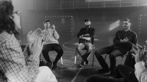 A black and white image of a support group engaged in a therapy session.