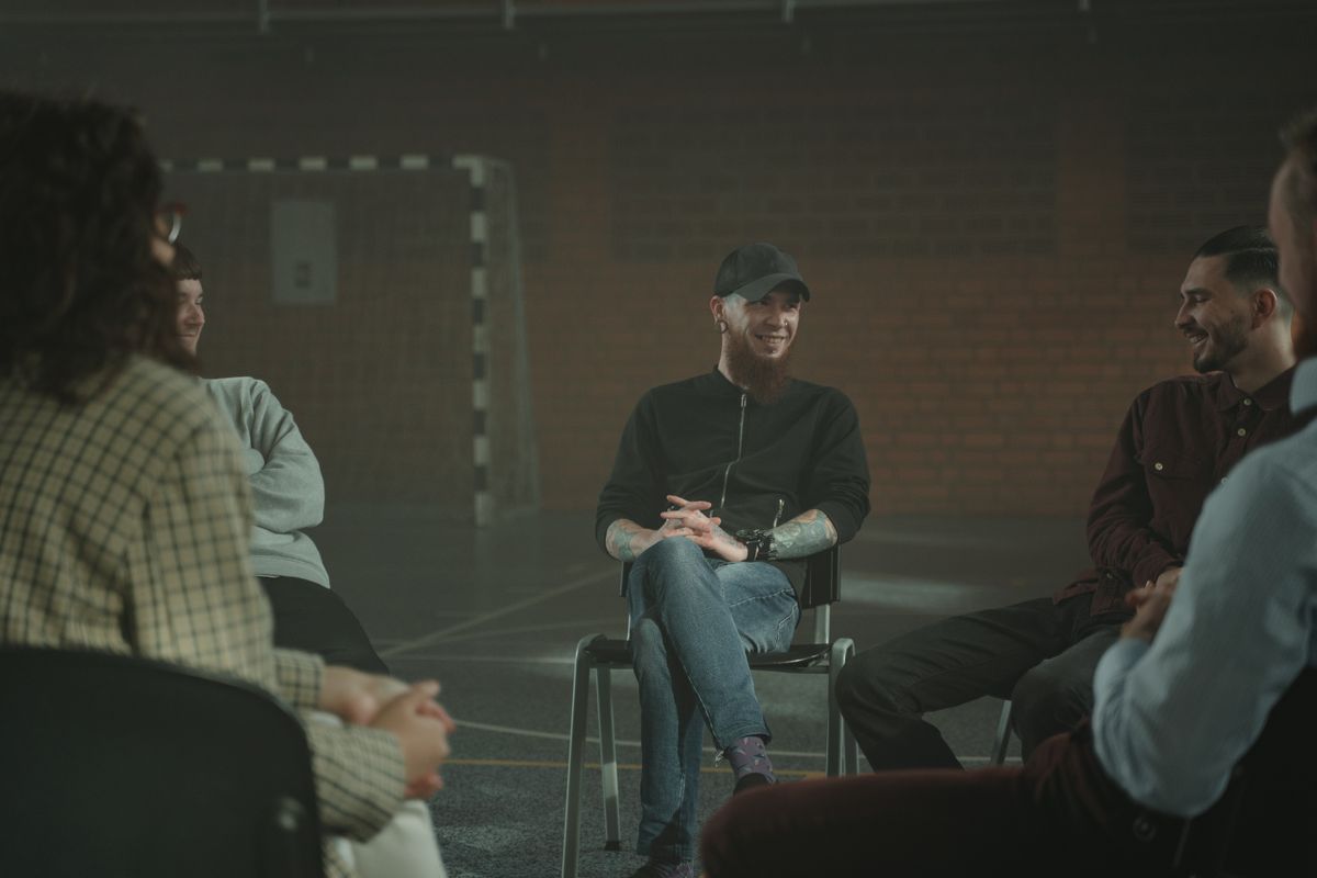 A group of people sharing and supporting each other in a group therapy circle