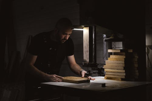 Focused craftsman carving wooden board