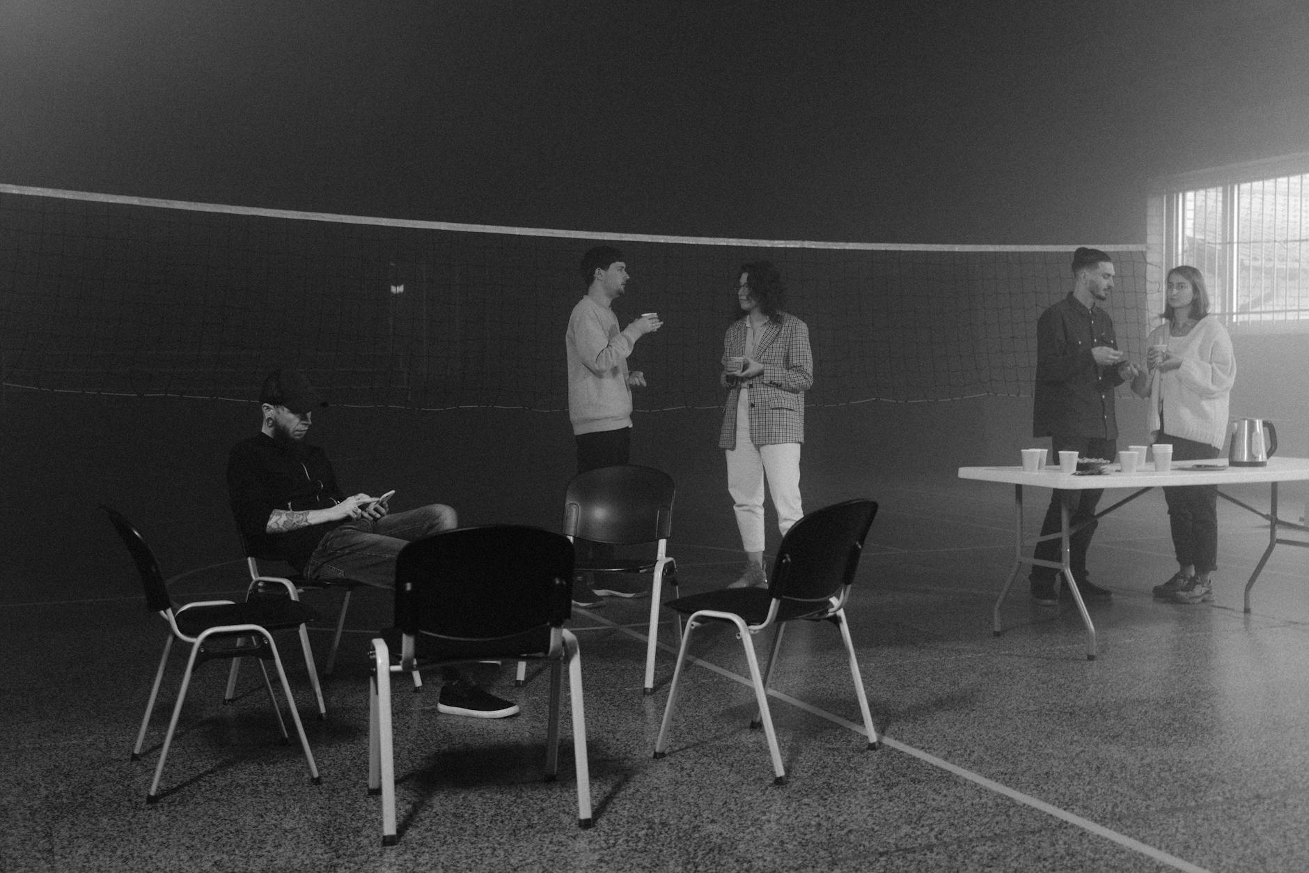 Grayscale Photo of Man and Woman Sitting on Chair