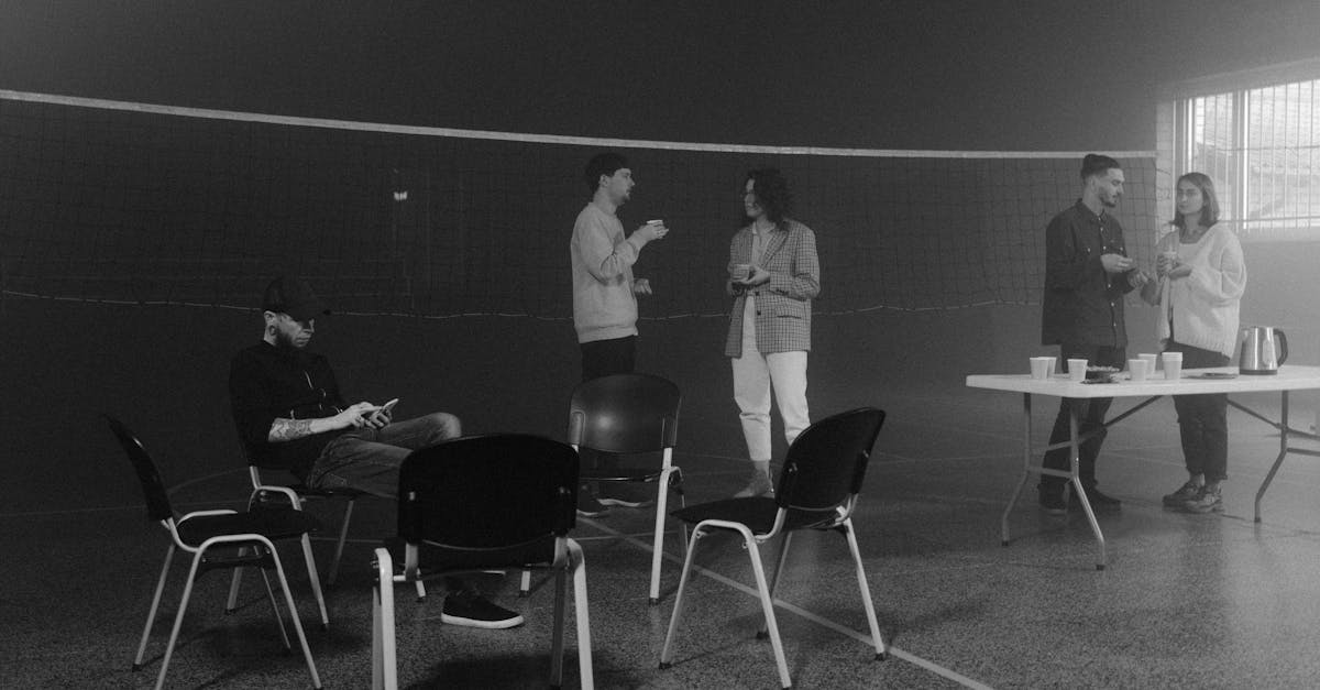 Grayscale Photo of Man and Woman Sitting on Chair
