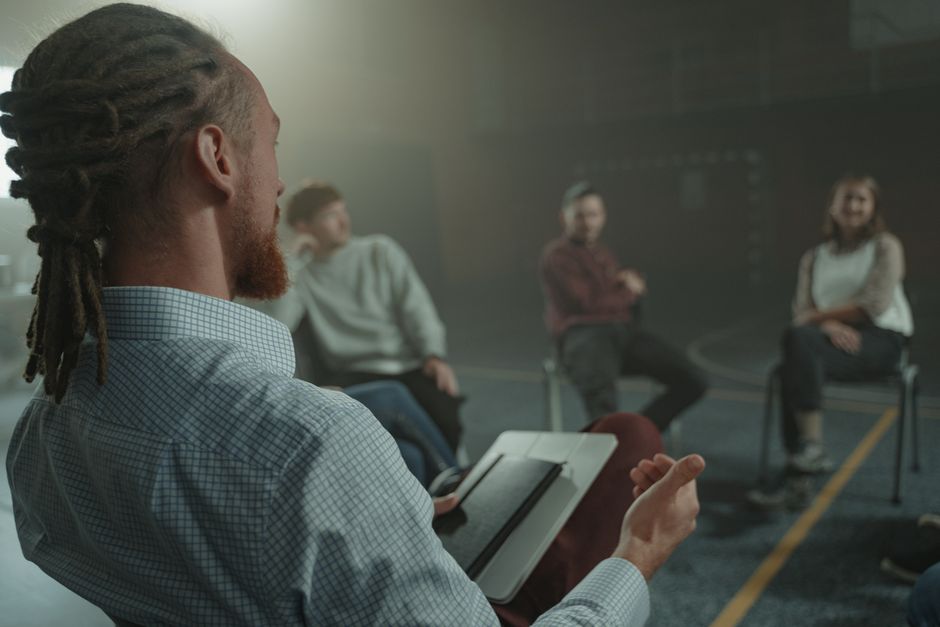 A warm, therapeutic group therapy session with individuals sitting in comfortable chairs in a cozy, sunlit room A warm, therapeutic group therapy session with individuals sitting in comfortable chairs in a cozy, sunlit room