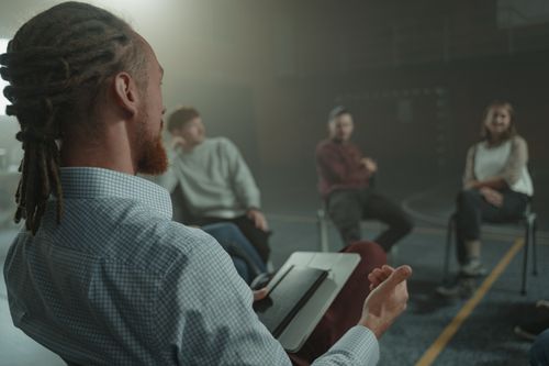 Free A group of adults engaged in a casual discussion indoors, focusing on communication and interaction. Stock Photo