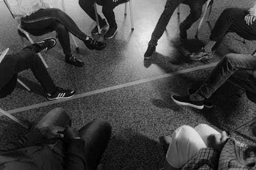 Grayscale Photo of People Wearing Shoes