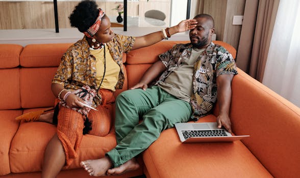 A concerned woman checks her partner's temperature as he rests on the sofa, caring at home.