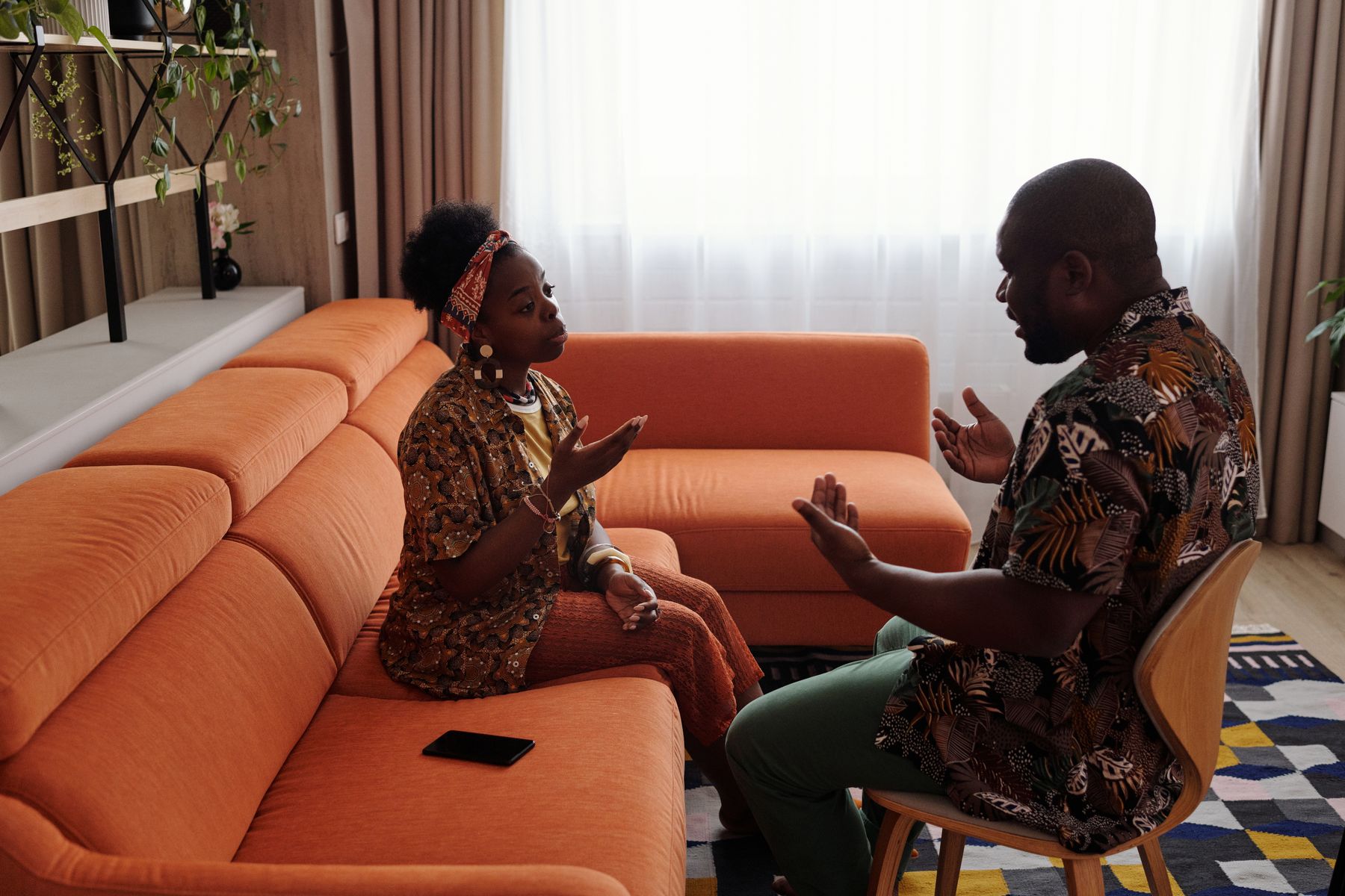Two adults mid-conversation in a warm living room — Diva Plavalaguna on Pexels