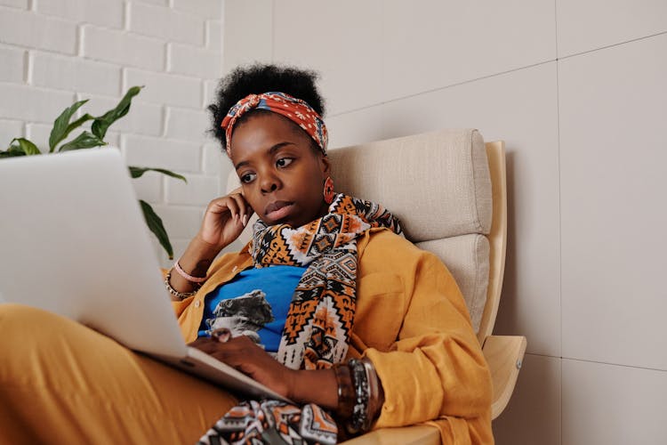 Photo Of A Woman With A Scarf Working On Her Laptop