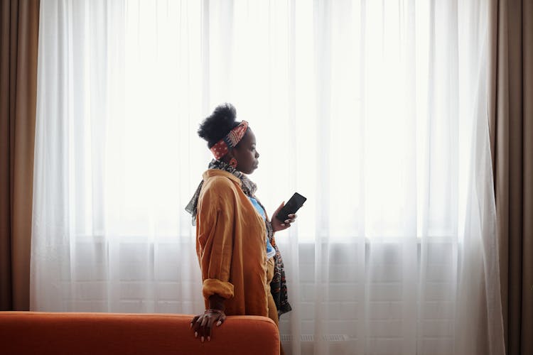 Side View Of A Woman Holding A Cell Phone