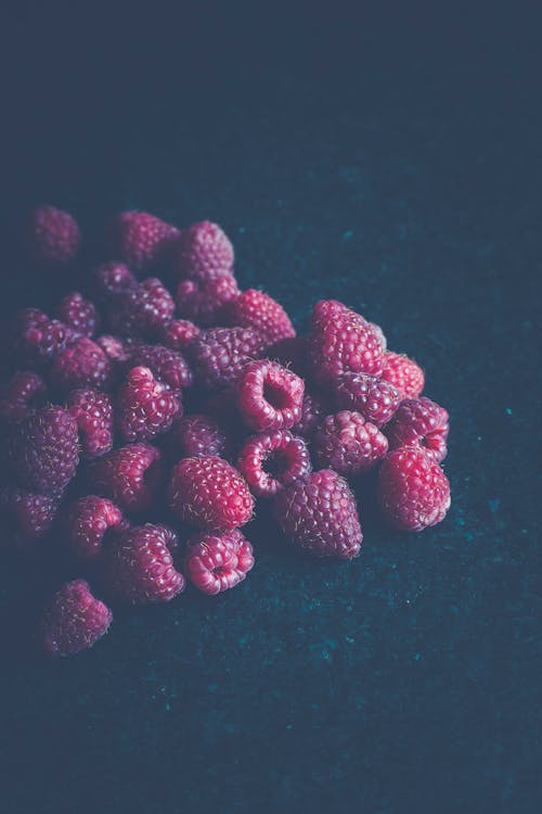 Red Raspberry Fruits on Blue Surface