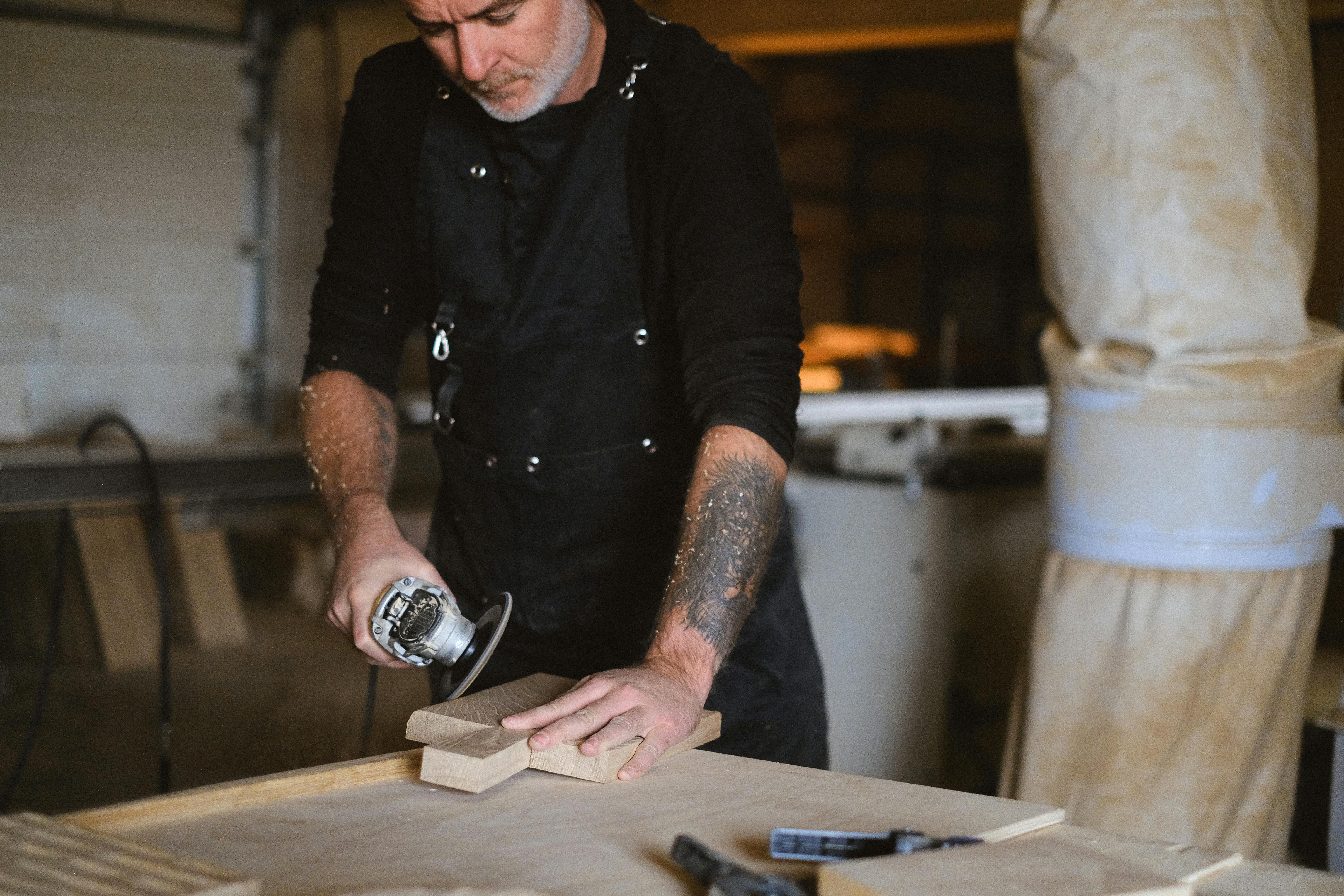 crop woodworker polishing wood in workshop