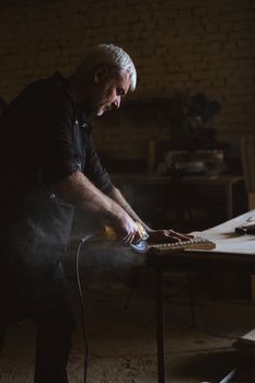 Focused craftsman working with angle grinder in carpentry