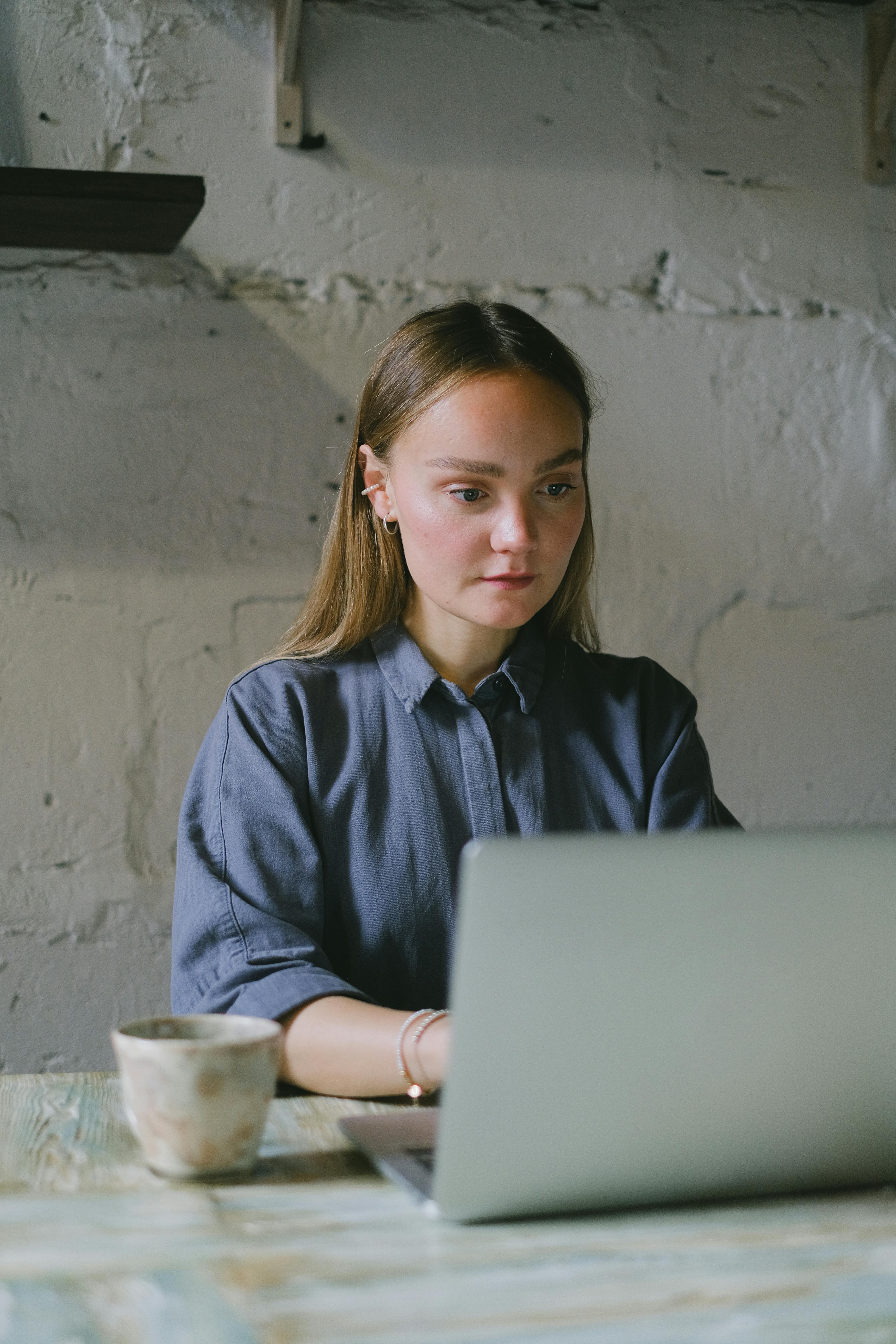 concentrated female freelancer using laptop in loft