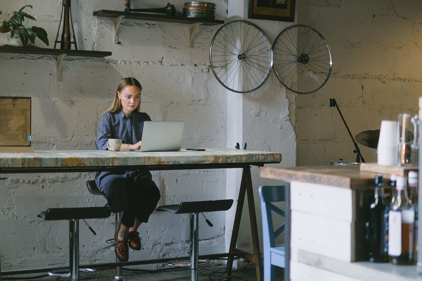 A person working on a laptop at a table in a bright modern café