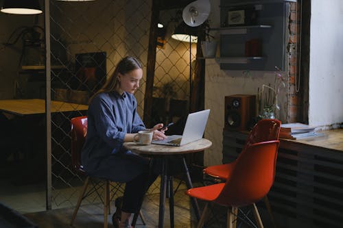 Serious woman browsing laptop in cafe