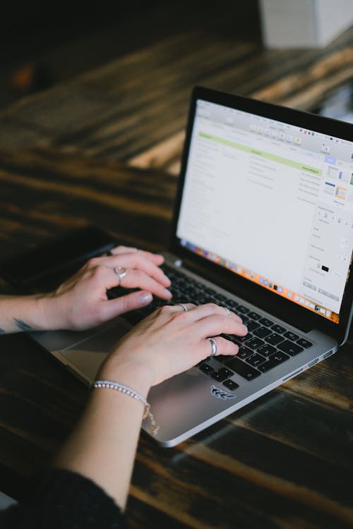 Crop woman browsing modern laptop