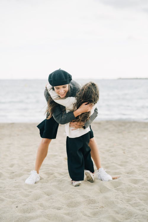 Photo of a Mother Hugging Her Child at the Beach