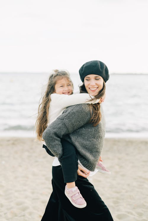 Photo of a Mother Smiling while Carrying Her Child