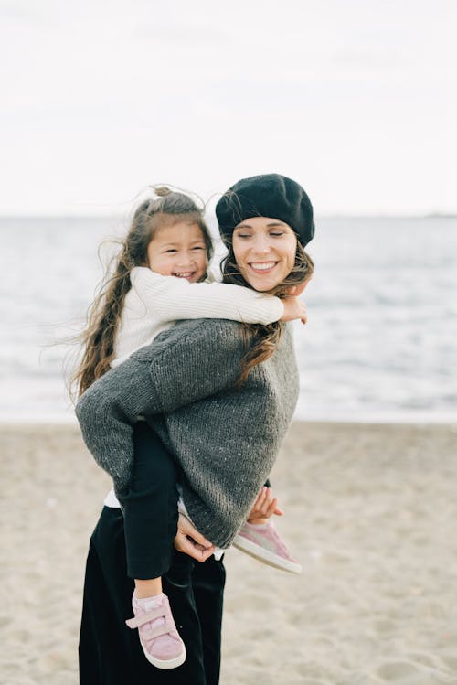 Free Photo of a Mother and Her Daughter Smiling at the Beach Stock Photo