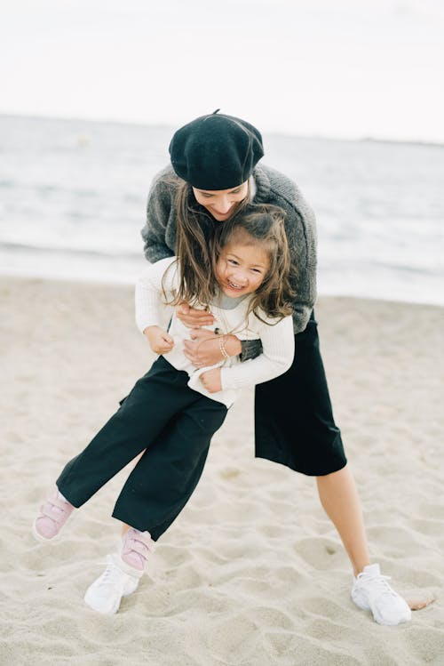 Happy Mother and Daughter Playing on Beach