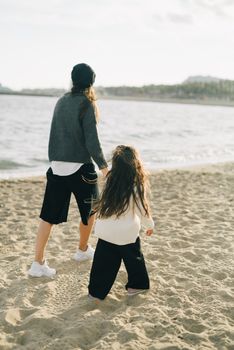 日落时分，母女俩牵着手在沙滩上散步