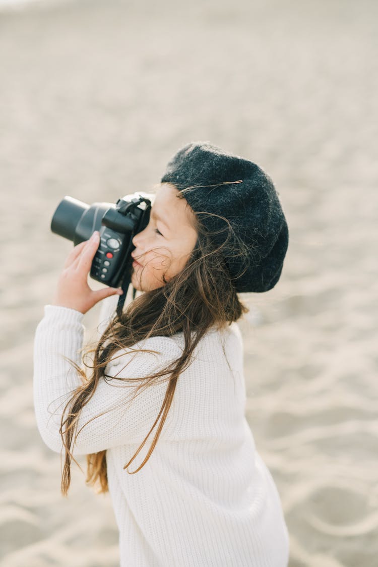 Girl Taking Pictures With Camera On Beach